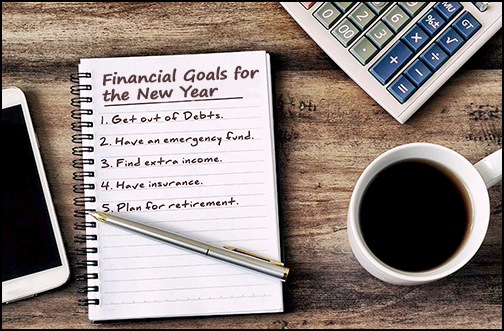 Cup of coffee and a note pad with a list of financial goals for the new year